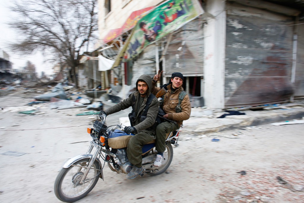 Due combattenti YPG (Unità di difesa del popolo) sfrecciano nella città di Kobane appena liberata
